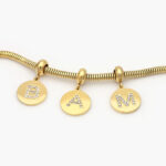 Dije Inicial Acero Inoxidable Tono Oro 0320